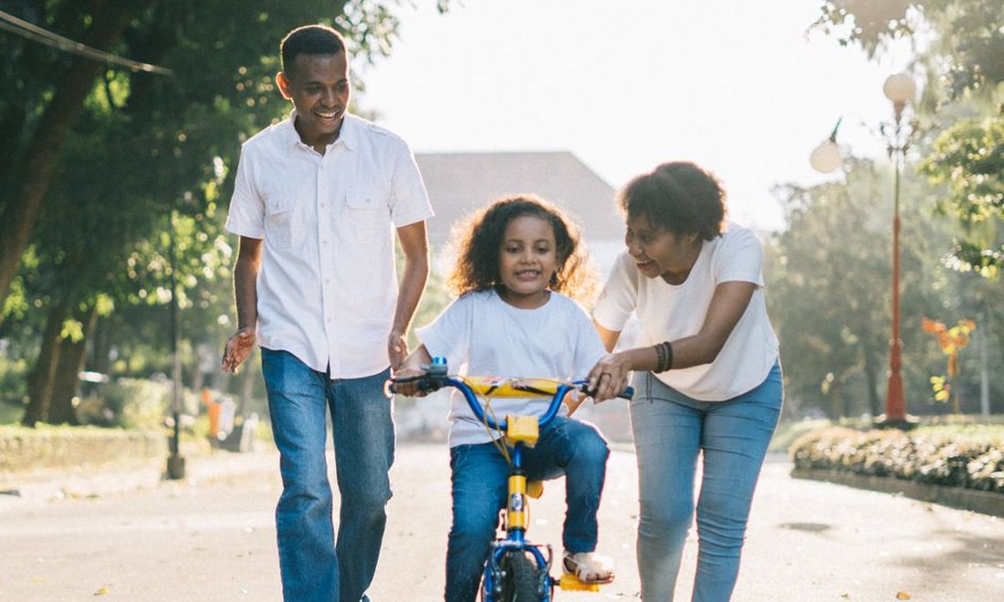 A family of three walking together in a park